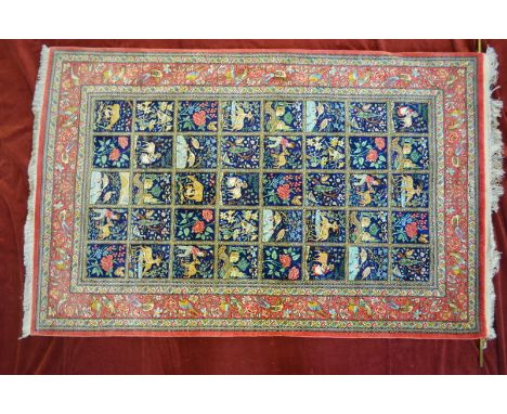 A fine Persian silk Quom rug, 2nd half 20th century, the rich blue ground with forty tile design of gardens, buildings, anima