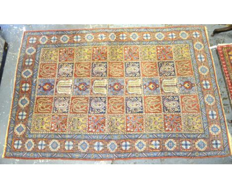 A Persian Qom rug, the tile design of boteh and floral emblems on red/blue ground, 136 x 210 cm