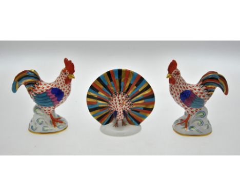 A pair of Herend porcelain cockerels, 23.5 cm high and a peacock, 11 cm high (3) Condition Report Comb broken to one cockerel
