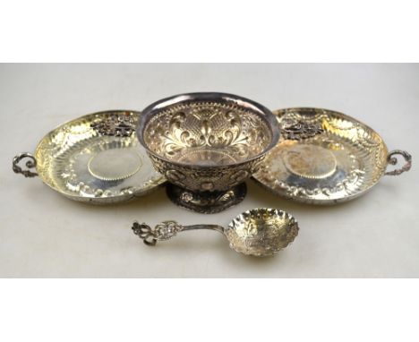 A matched pair of embossed silver wine-dishes with cast scroll handles, London 1913/16, 13 cm diameter, to/w a Continental em