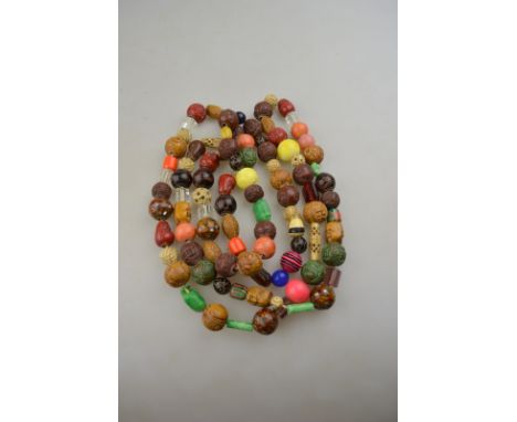 A long row of Oriental multi-coloured carved, polished and faceted beads including jade, bone, glass etc, various ages and ma