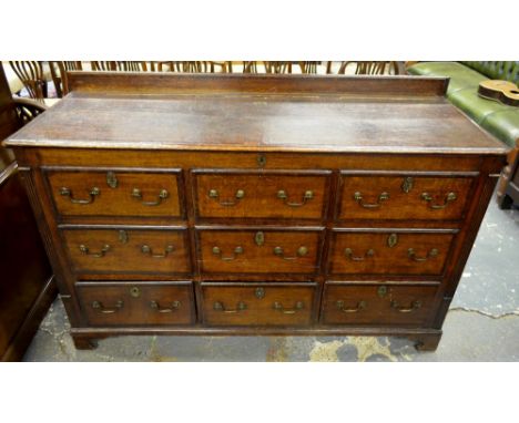 An 18th century cross-banded oak mule chest, the hinged top over a storage well with six dummy drawer fronts and three drawer