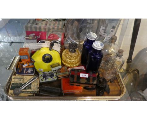 A Tray of Curios to Include Vintage Bottles, Enamelled Bed Chamber Stick, Spring Balances, Vintage Tins Etc