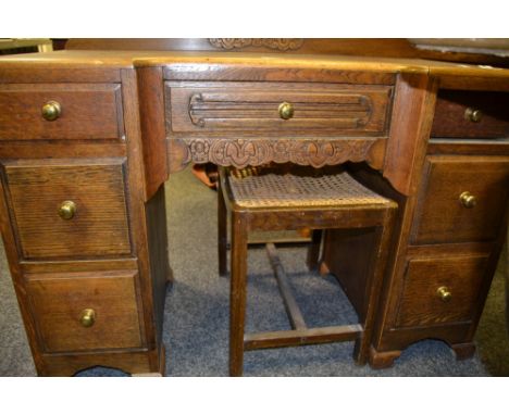 A 1930s oak knee hole desk, central door flanked by smaller drawers;  a bergere seated dressing table stool