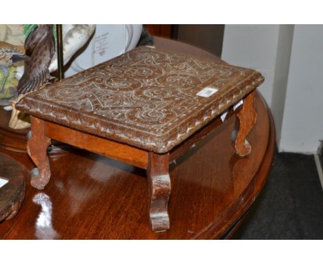 A rectangular carved oak foot stool, shaped supports