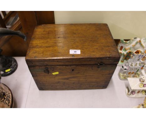 An early 20th Century golden oak trinket box containing three pewter measures and a bronzed cherub ornament
