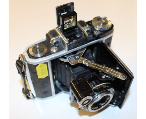 A Zeiss Ikon camera with brown leather carrying case; together with a lens 