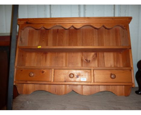 A modern pine wall shelf fitted three drawers