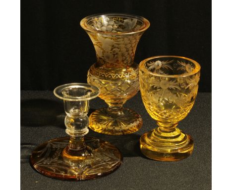 A Bohemian amber flashed glass ogee shaped pedestal vase, engraved with a band of fruiting vine, 15cm; a similar amber flashe