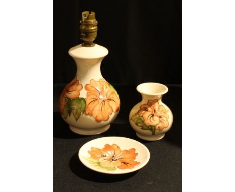 A Moorcroft Magnolia pattern baluster table lamp, 16cm; others similar ovoid vase, 10cm; circular dish, 12cm diam (3) 