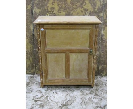 A small stripped pine hanging wall cabinet enclosed by a triple moulded panelled door with fixed shelf to interior, 66 cm hig