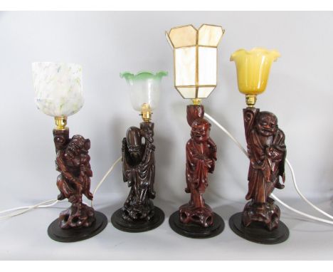 Four Chinese root carved table lamp base figures, Shoulao, an Immortal and two Laughing Buddhas, each with decorative glass s