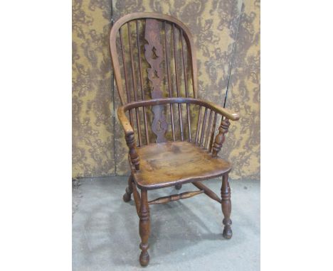 A 19tth century Windsor hoop and stick back armchair with central pierced splat over a saddle shaped seat raised on turned su
