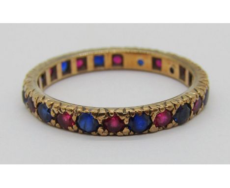 Yellow metal eternity ring set with blue and pink gems (possibly synthetic), size Q/R, 2.3g