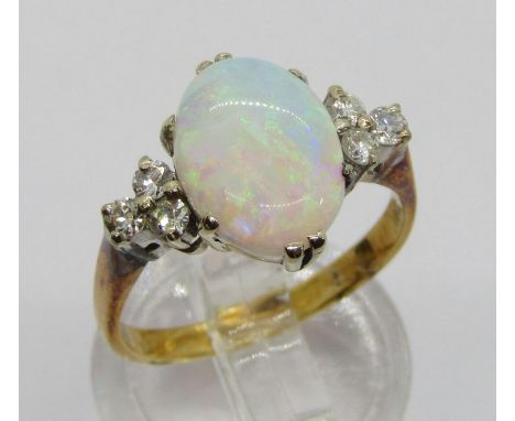 Early to mid-20th century 18ct opal and diamond ring, the claw set oval opal flanked by a pair of diamond trefoil clusters, d