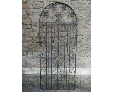 A vintage heavy gauge ironwork pedestrian side gate of arched form with decorative scroll work detail 202cm h x 87cm (full wi