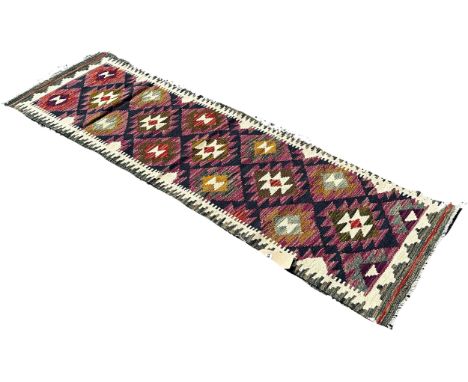 A Maimana kilim runner with alternating stepped diamonds on a purple ground, 200cm x 58cm approximately