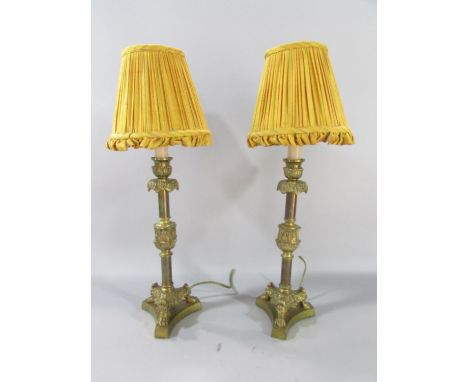 A pair of vintage brass candlestick table lamps on hairy paw supports, with vintage shades 37cm high.
