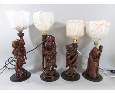 Four Chinese root carved table lamp figures, two Shoulao, one Immortal and one Laughing Buddha each with a decorative glass l