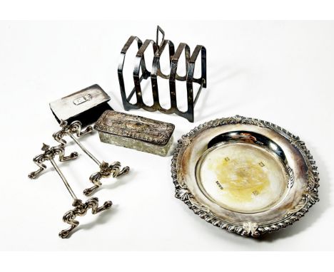 A silver card tray, 14 cm diameter, together with a silver toast rack, a pair of silver knife rests, a silver matchbox cover 