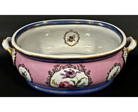 A large ceramic foot bath with floral bouquet detail upon a pink ground within blue and gilt banded borders, crossed swords m