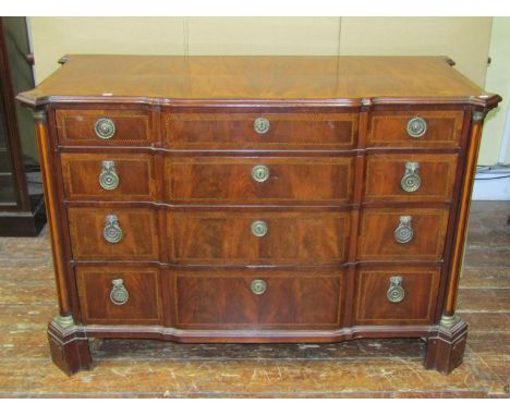 A Dutch breakfront commode of four long drawers with rams mask drop ring handles, with chevron banded detail, the canted corn