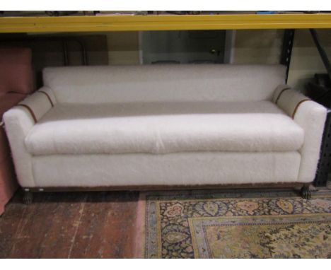 A 'Safari Sofa' (Justin Van Breda) upholstered in cream coloured brushed wool finish with leather strap work decoration to th