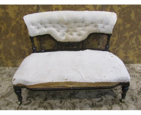 An Aesthetic movement low two seat drawing room/bedroom sofa with simple base covered upholstered seat and button back within