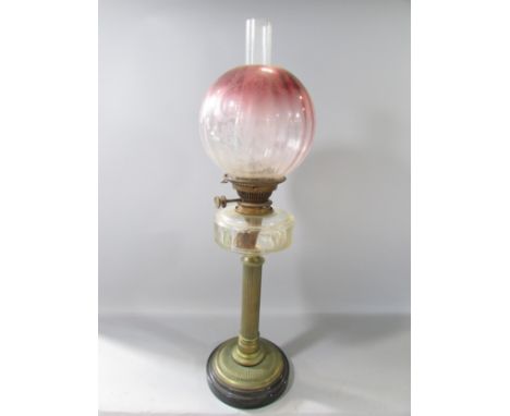 A Victorian reeded brass column oil lamp with receding purple glass shade and Hinks No 2 lever, 65cm high.