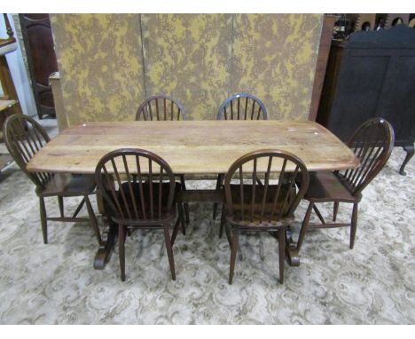 A stained oak refectory table (probably Ercol), the rectangular top with moulded outline raised on shaped supports united by 