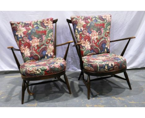 A pair of Ercol elm stick back armchairs with loose cushions, webbing requires attention, some wear to arms. Not available fo