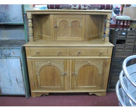 Light Oak Court Cupboard, top with a single cupboard door, with arched decoration, over two small drawers, twin panelled door
