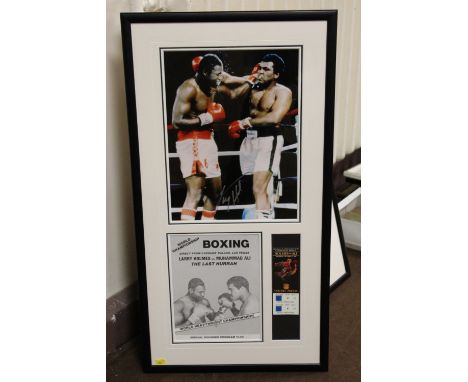 MUHAMMAD ALI - A FRAMED COLOUR PICTURE OF ALI AND LARRY HOLMES SIGNED BY HOLMES, together with a programme copy and a ticket 