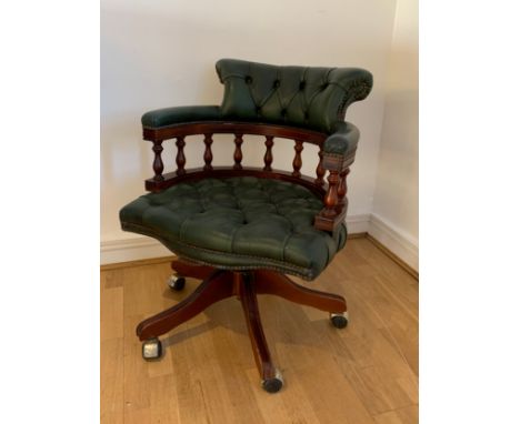 A mahogany framed green leather button back captain's chair by Ring Mekanikk, Norway, with swivel height adjustment, on casto