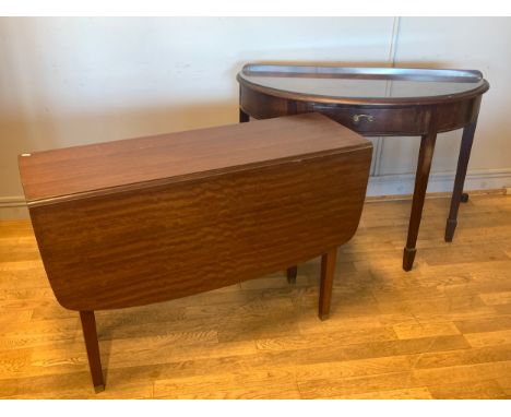 A mahogany demi lune console table, having central draw with drop brass handle, raised on square tapered legs, W108cm, H78cm,