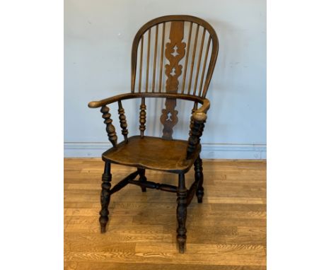 A late 19th early 20th century high back windsor chair, stick back with central carved splat, shaped seat on turned legs and 