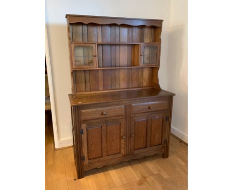 Modern light wood kitchen dresser with glazed top section over a base with two drawers and two cupboards, doors opening to re