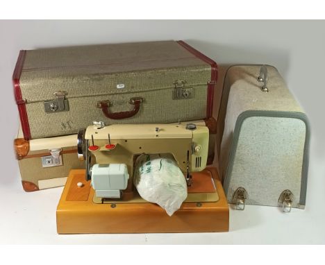 Two mid 20th century electric Singer sewing machines, together with a 1950s electric freestanding fire and two 1960s suitcase