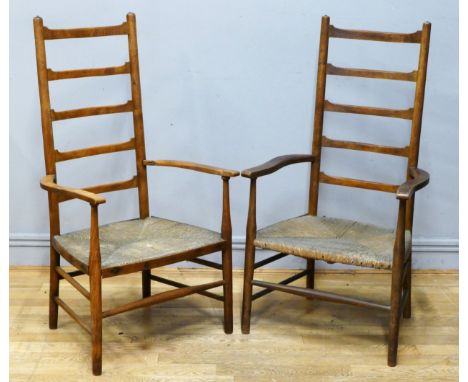 A pair of arts and crafts beech and rush seated ladder back armchairs, height 102cm.  Left side (rear) armrest to one chair h