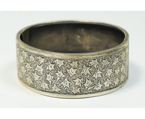 A Victorian silver hinged bangle, stamped STD SILVER, the front with engraved ivy leaf decoration, 23mm wide, 22gm. Often see