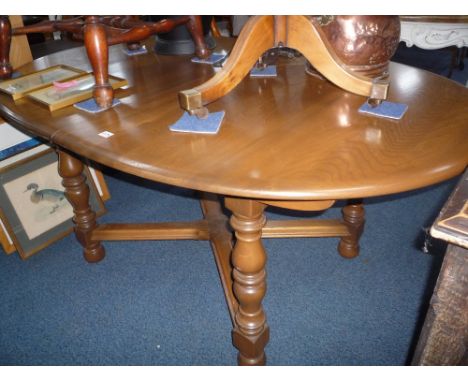 AN 'ERCOL' EXTENDING DINING TABLE
