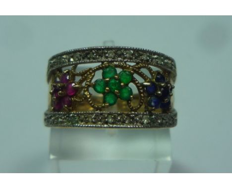 A 9CT GOLD DRESS RING, designed as three flowers with diamond borders, to include emerald, sapphire and rubies, ring size N 1