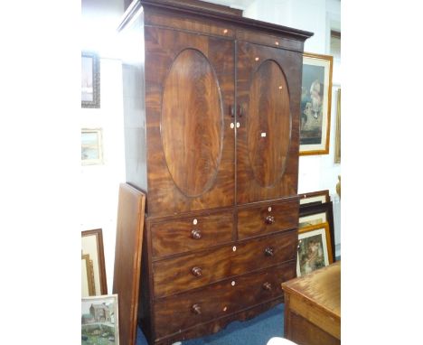A GEORGIAN MAHOGANY LINEN PRESS, the top with twin oval panelled doors opening to reveal five sliding trays above two short a