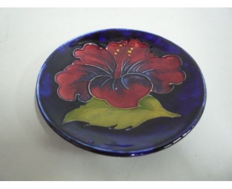 A MOORCROFT POTTERY TRINKET DISH, 'Hibiscus' pattern, paper label and impressed marks to base, diameter 12cm