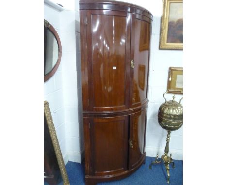 A MAHOGANY FLOORSTANDING BOW FRONTED CORNER CUPBOARD, with four doors (key)