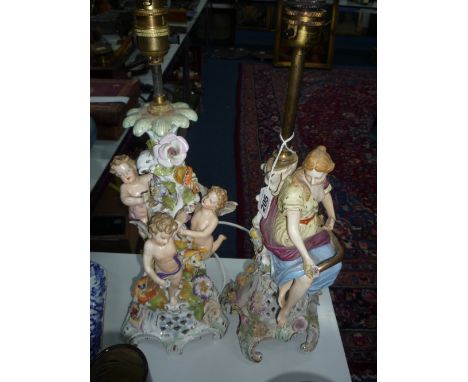 A DRESDEN CENTREPIECE CONVERTED TO A LAMP BASE, decorated with cherubs and foliage, together with another similar with Maiden