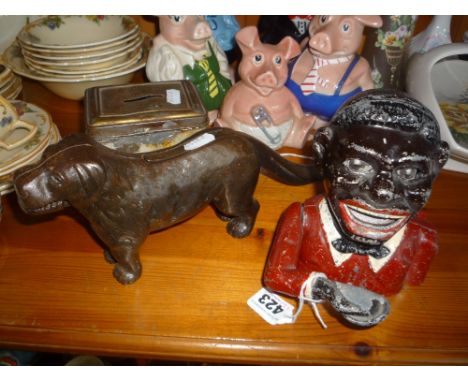 A 'JOLLY' MONEY BANK, a cast dog shaped nut cracker No 273480 and a money tin (3)