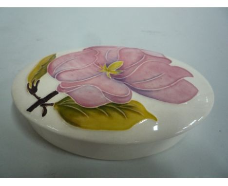 A MOORCROFT POTTERY OVAL COVERED TRINKET POT, 'Magnolia' pattern, impressed marks to base, approximate length 13cm