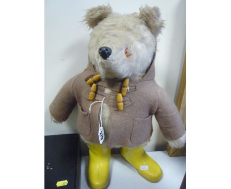 A GABRIELLE DESIGNS PADDINGTON BEAR, missing hat and label, but has fawn duffel coat and yellow Dunlop wellington boots, Gabr