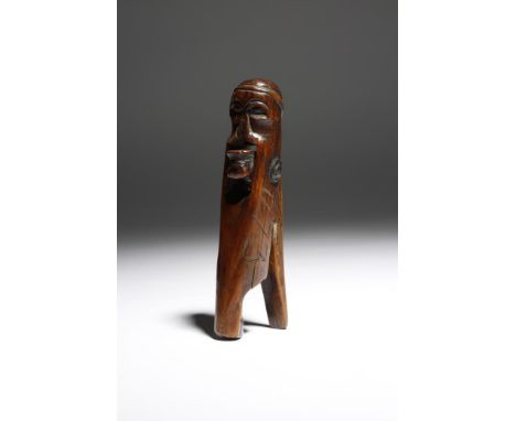 A mid-18th century treen primitive lever action nutcracker, in the form of a man wearing a hat and with a flat face, inscribe
